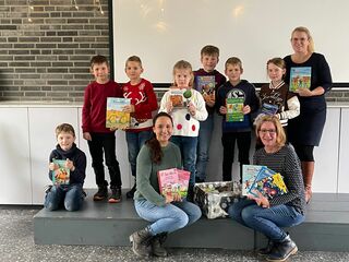 Ina Koppers und Susanne von Loe vom Förderverein überreichen den Kindern und Schulleiterin Verena Hazenberg die Bücher.