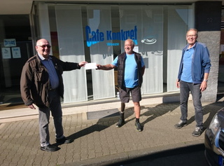 (v. l. n. r.): Jürgen Heinze, Klaus Oberreich und Johannes Masseling bei der Spendenübergabe vor dem Café Konkret.