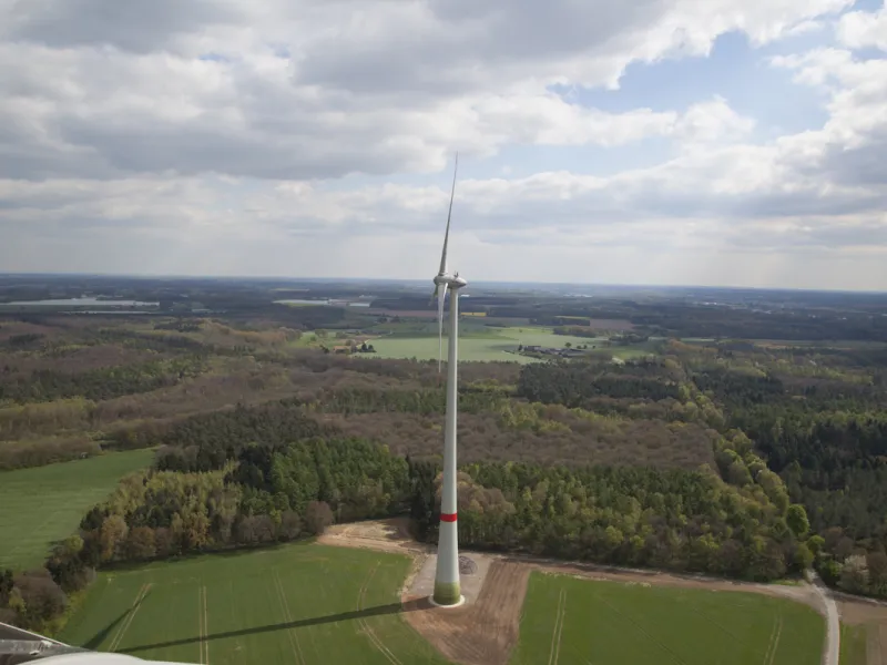 Eine Windkraftanlage auf einer schönen Landschaft.