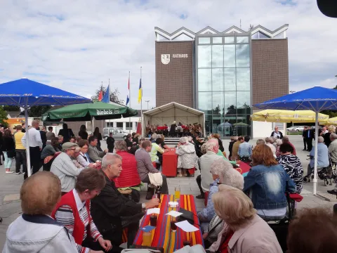 Ausschnitt aus dem Grenzenlosen Konzert 2013 in Weeze Teilnehmende am Grenzenlosen Konzert in Weeze 2013 an Tischen vor der Bühne