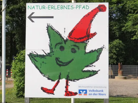Schild des Natur-Erlebnis-Pfades mit Pfeilrichtung führend nach links
