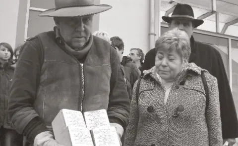 Gunter Demnig, Edith Bader, Bürgermeister Ulrich Francken setzen 2009 Stolpersteine Eine Person mit Stolpersteinen in der Hand und zwei Personen schauen zu