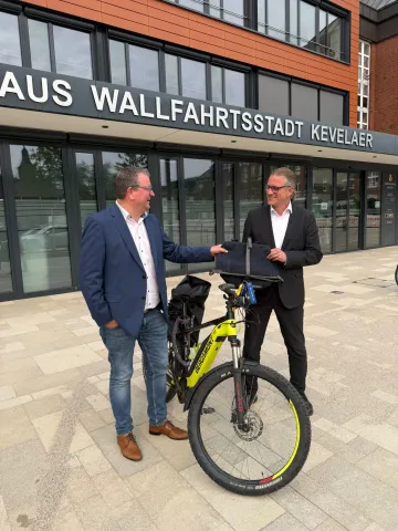 Bürgermeister Koenen übergibt die Staffeltasche an Bürgermeister Pichler in Kevelaer Staffelfahrt durch den Kreis - Weeze übergibt die Staffeltasche in Kevelaer